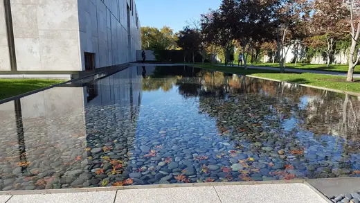 Photo 2: Exterior · A shallow reflecting pool featuring smooth stones and leaves on the bottom