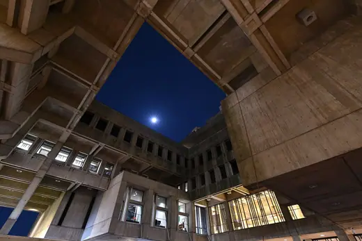 Photo 4: Exterior · The courtyard at Boston City Hall at night, with the moon visible