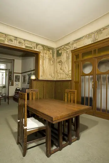 Photo 6: Interior · Ontvangstruimte in het Cauchiehuis met grote fries in sgraffito en aangepast meubilair (overzichtsfoto)