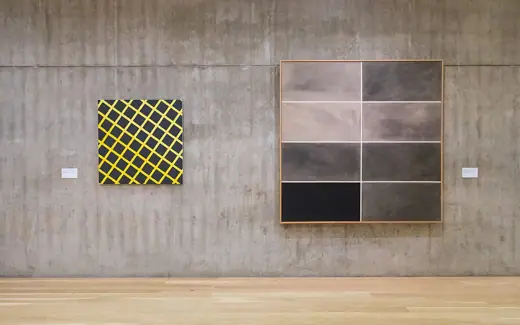 Photo 6: Interior · Deux oeuvres modernes accrochées sur un mur en béton nu, avec un plancher beige clair