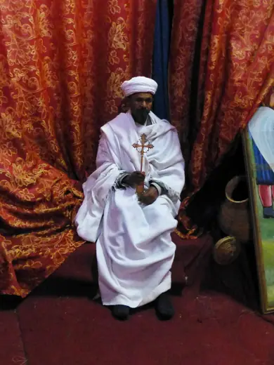 Photo 6: Interior · Prêtre orthodoxe présentant une croix de procession à l'église Saint-Georges de Lalibela (Ethiopie)