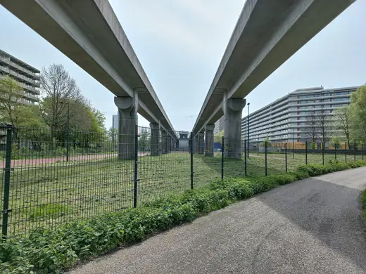 Photo 4: Exterior · Bijlmerdreefmetrobrug (brug 1613) bij de Grubbezee, Amsterdam-Zuidoost; links Kleiburg, rechts Kruitberg