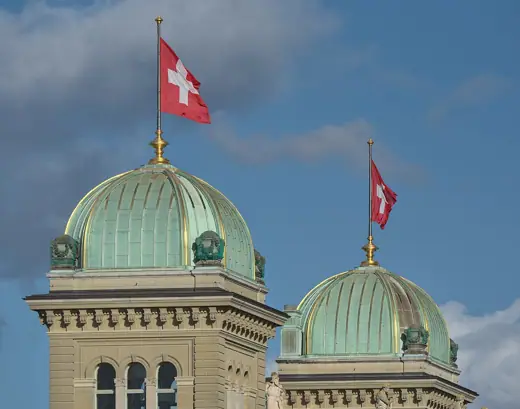 Photo 2: Exterior · Copper-covered towers of the parliament building of the Federal House in Bern with Swiss national flags