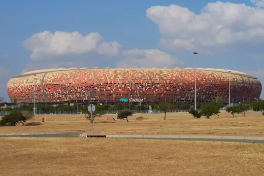 Photo 1: Exterior · FNB Stadium (Soccer City) viewed from the surrounding parklands