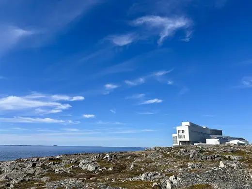 Photo 3: Exterior · Fogo Island Inn and the Atlantic Ocean, viewed from the south on June 6, 2026