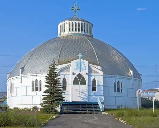 Photo 3: Exterior · Straight-on front view of Our Lady of Victory Church , Inuvik , NT, Canada, in 9:30 p.m