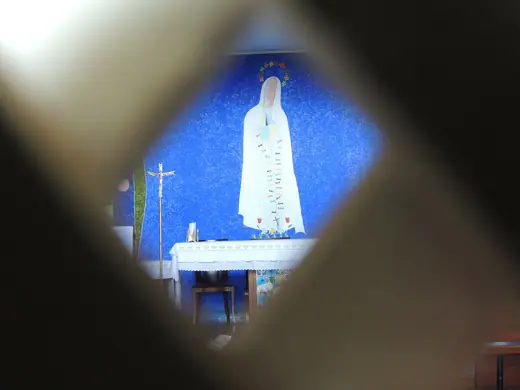 Photo 5: Interior · Interior da Igrejinha de Nossa Senhora de Fátima visto através das frestas de sua porta de madeira