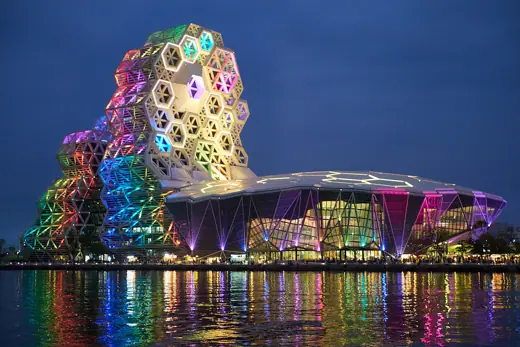 Photo 5: Context · The Kaohsiung Music Center illuminated at night, reflected in the harbor