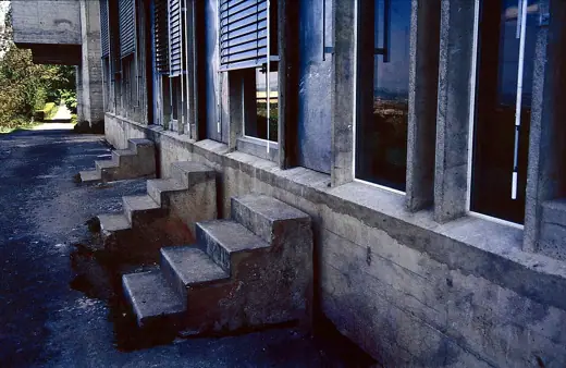 Photo 3: Exterior · Concrete stairs in front of the refectory, with the church and it´s bulged organ-construction in the back